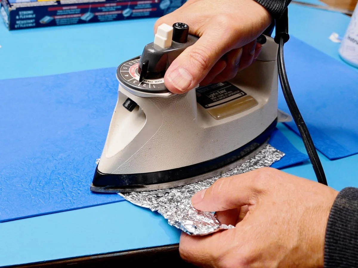 image of an iron pressing crinkled aluminum foil texture into foam