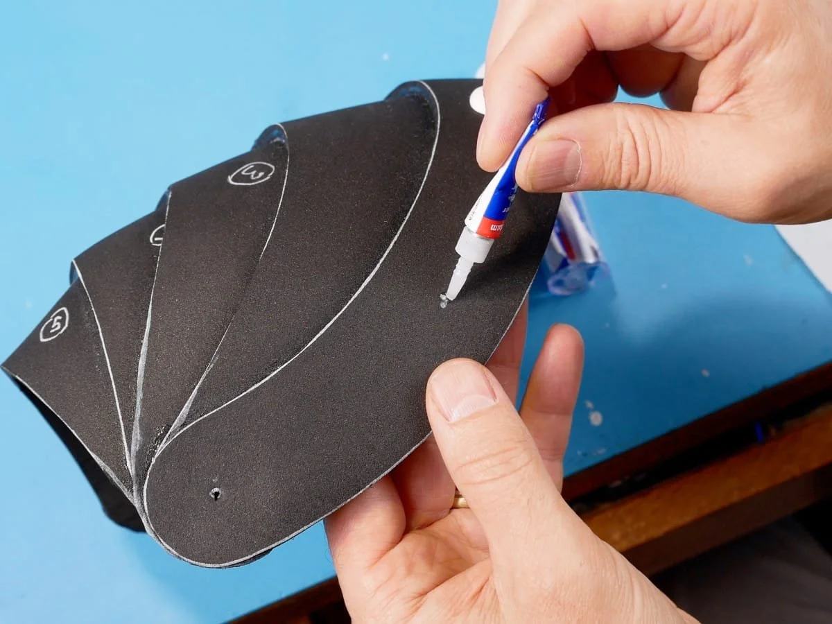 applying glue to the pauldron to attach the rivets