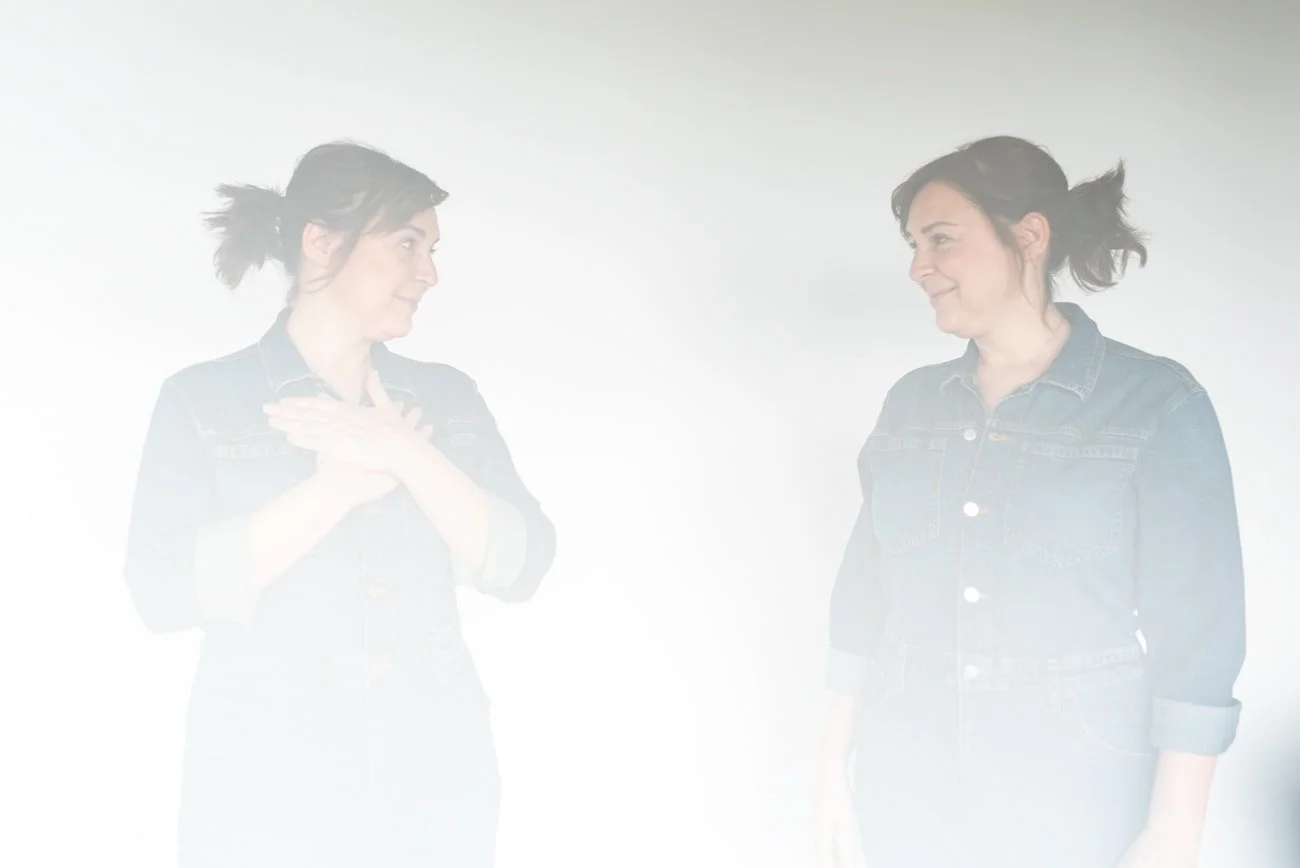 Universal consciousness coach looking at her own reflection in white space.