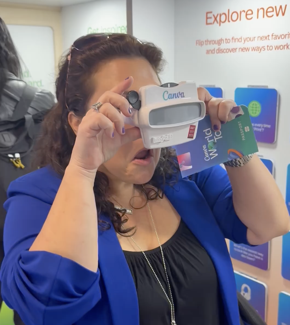 Woman trying on a pair of virtual reality goggles at an event or store, holding a membership card or ticket in her hand.