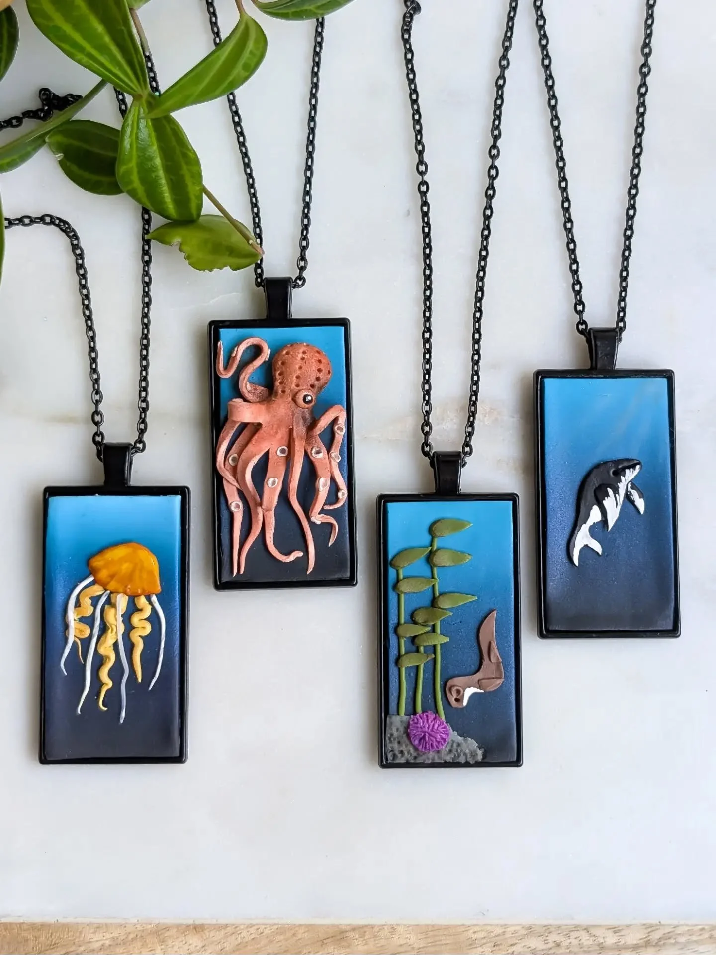Last month I created a series of marine life pendants and.... FORGOT to share them! 

I'm telling you... Sometimes social media is not my strength.

Anyway!  Here they are... A jellyfish, a wiggly octopus, a sea otter in a kelp forest, and a humpback