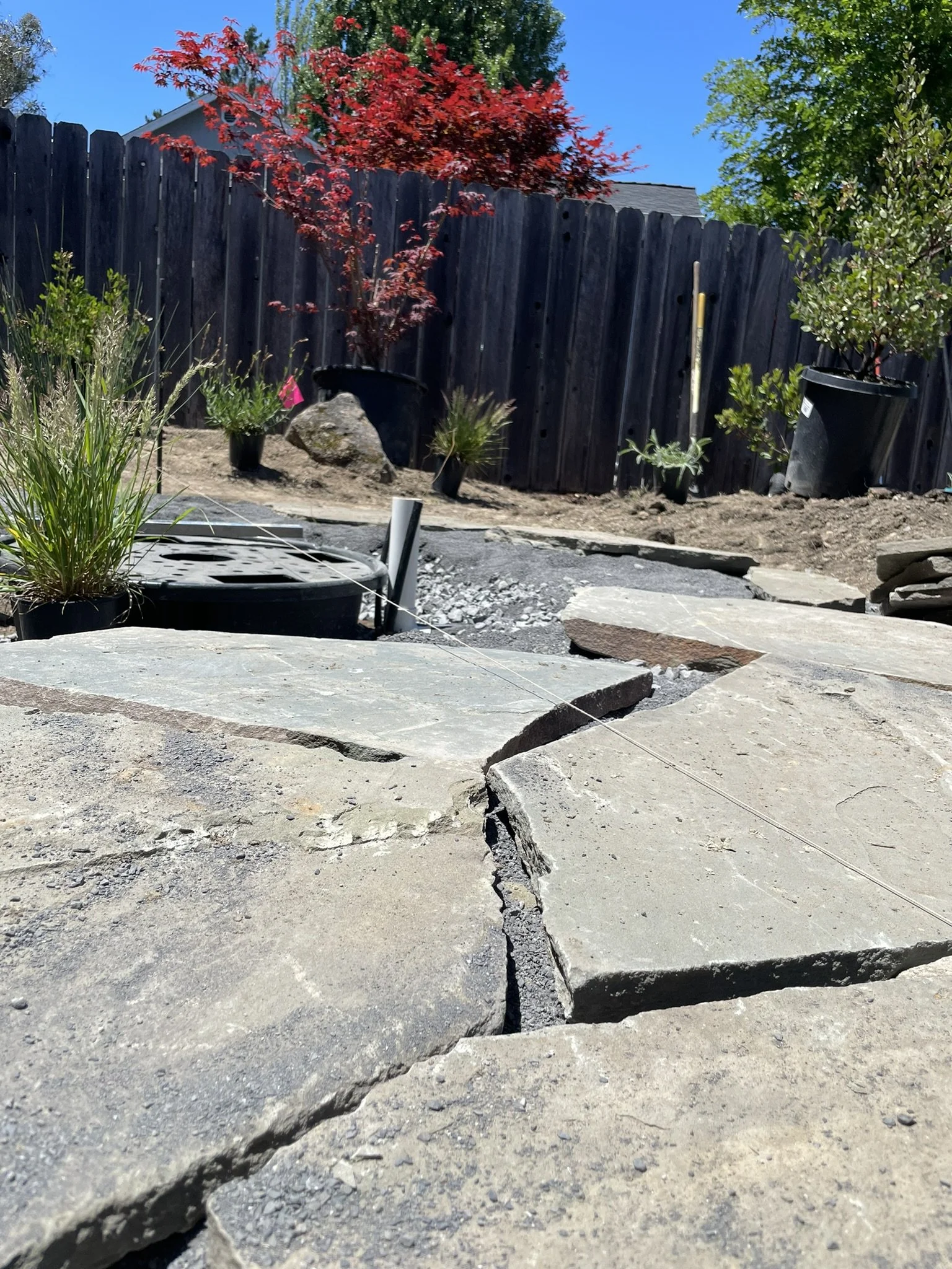In progress photo of the flagstone patio and recirculating boulder fountain feature being installed