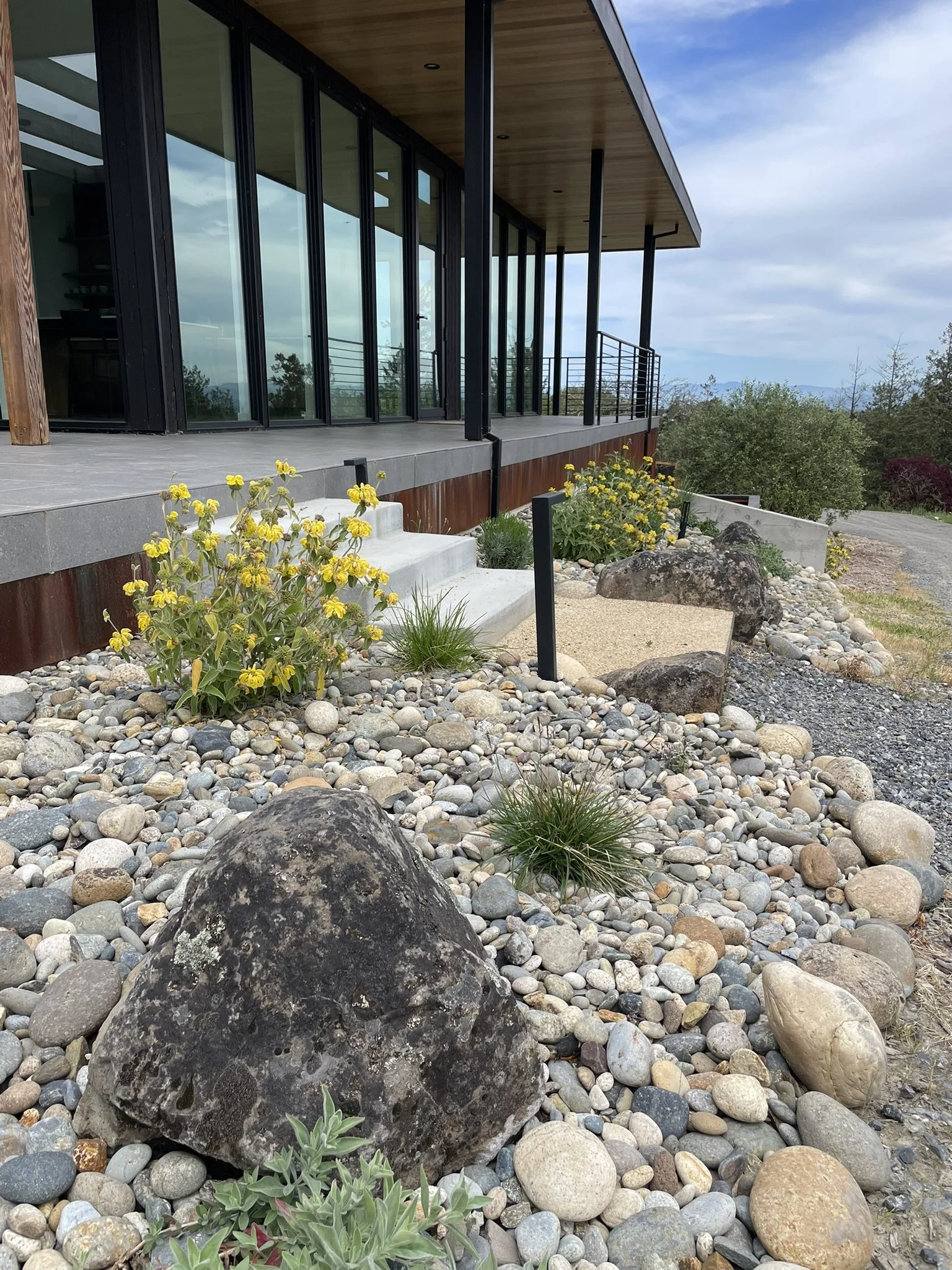 Low water-use plantings flank this staircase to the outdoor seating area. Pathlights are installed for easy access at night.