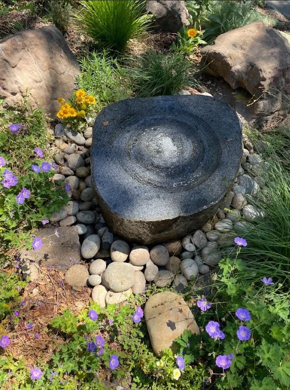 Pondless millstone fountain recirculates precious water for birds to preen while the gentle water sounds drift to the front home entrance and porch.