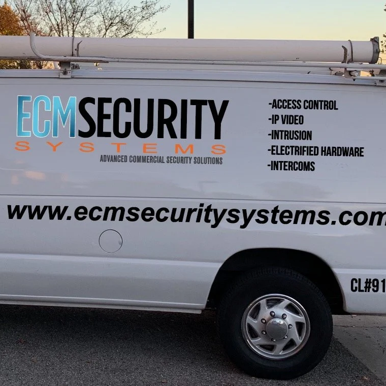 A white security service van with the company logo 'ECM Security Systems' and a list of security solutions, parked on a street.