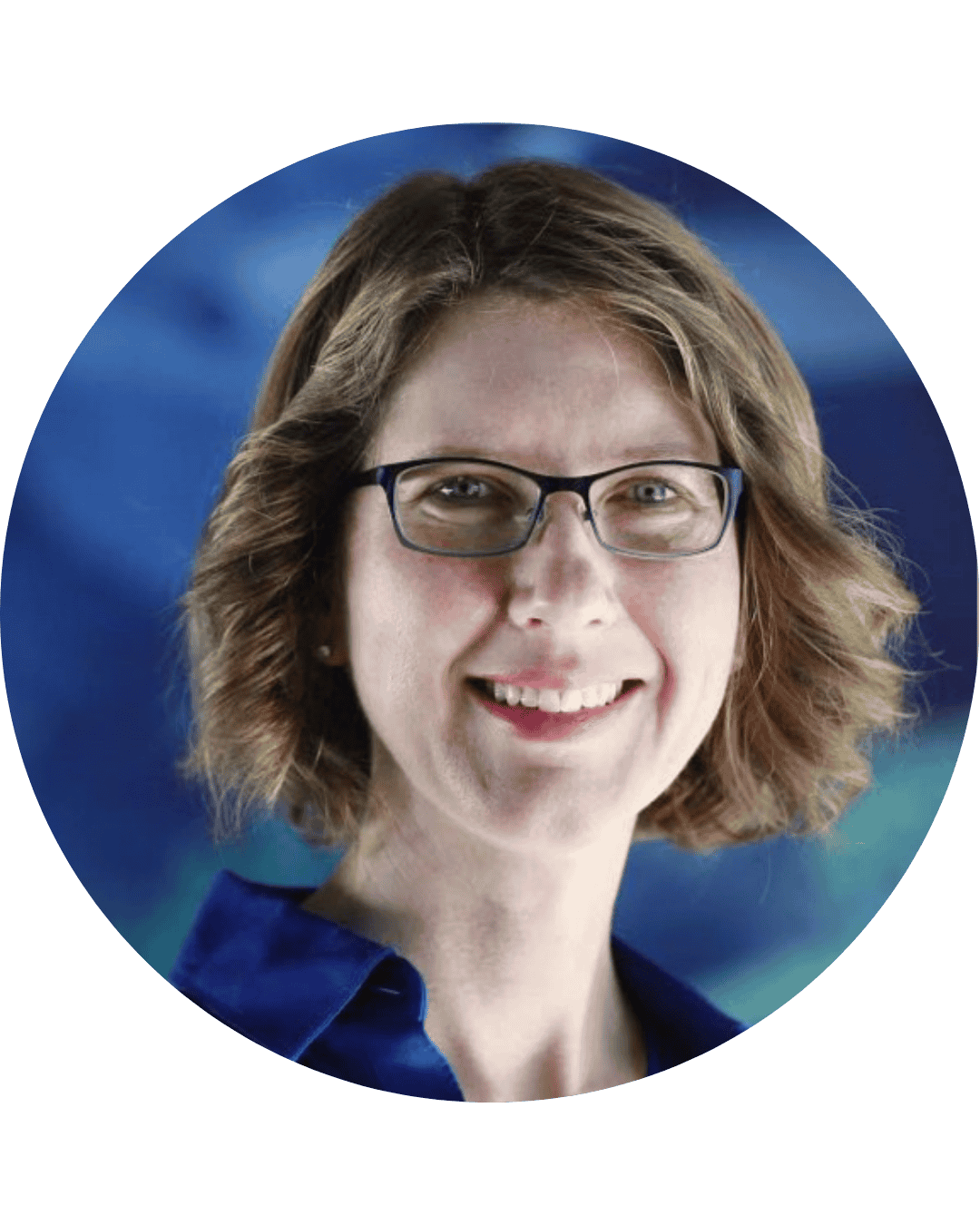 A woman with shoulder-length wavy hair, wearing glasses and a dark blue collared shirt, smiling at the camera, with a blurred blue background.