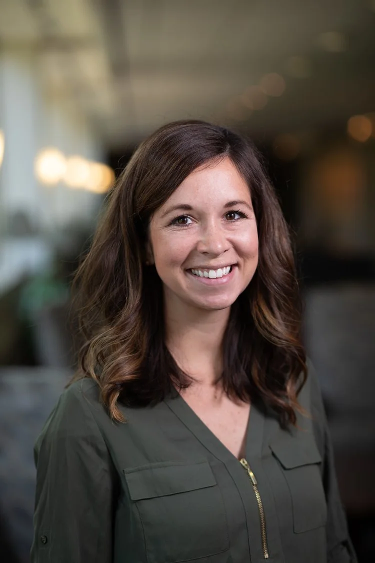 Ambria Crusan smiling at the camera, blurred background.