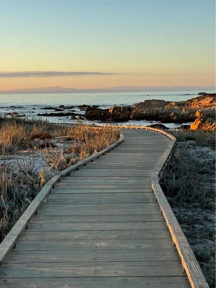 Coastal boardwalk leading toward the sea at sunset, representing upcoming Recovery Reimagined events and gatherings.