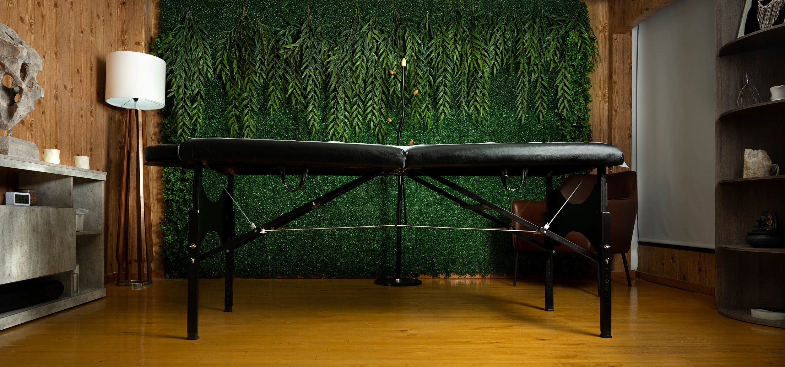Camilla especial frente a un muro vegetal en un espacio de diseño natural, parte de la experiencia sensorial que distinguen a los spas Monterrey.