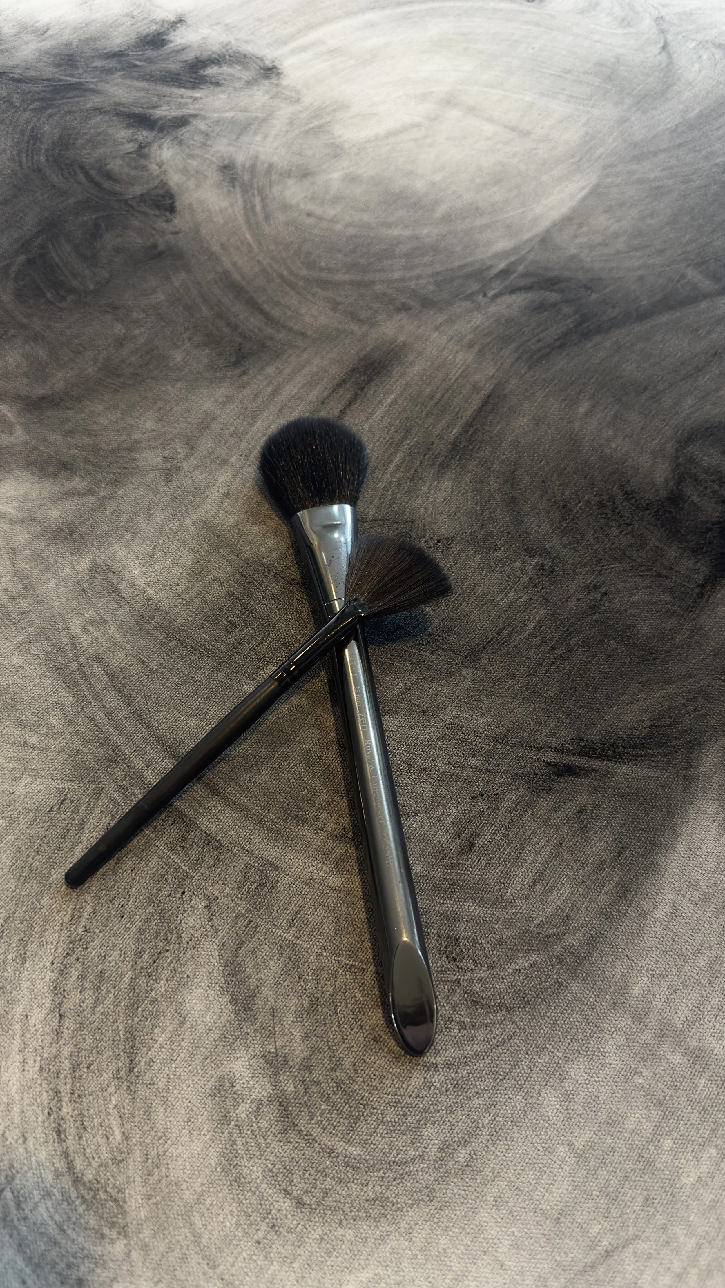 I find makeup brushes work better for picking up powdered charcoal