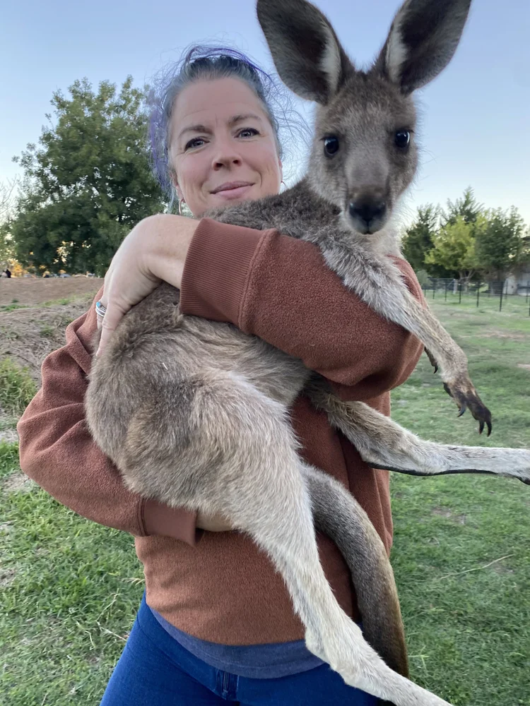 Jill holding a rescued kangaroo joey at WildSide Wildlife Shelter, Little Farm of Calm