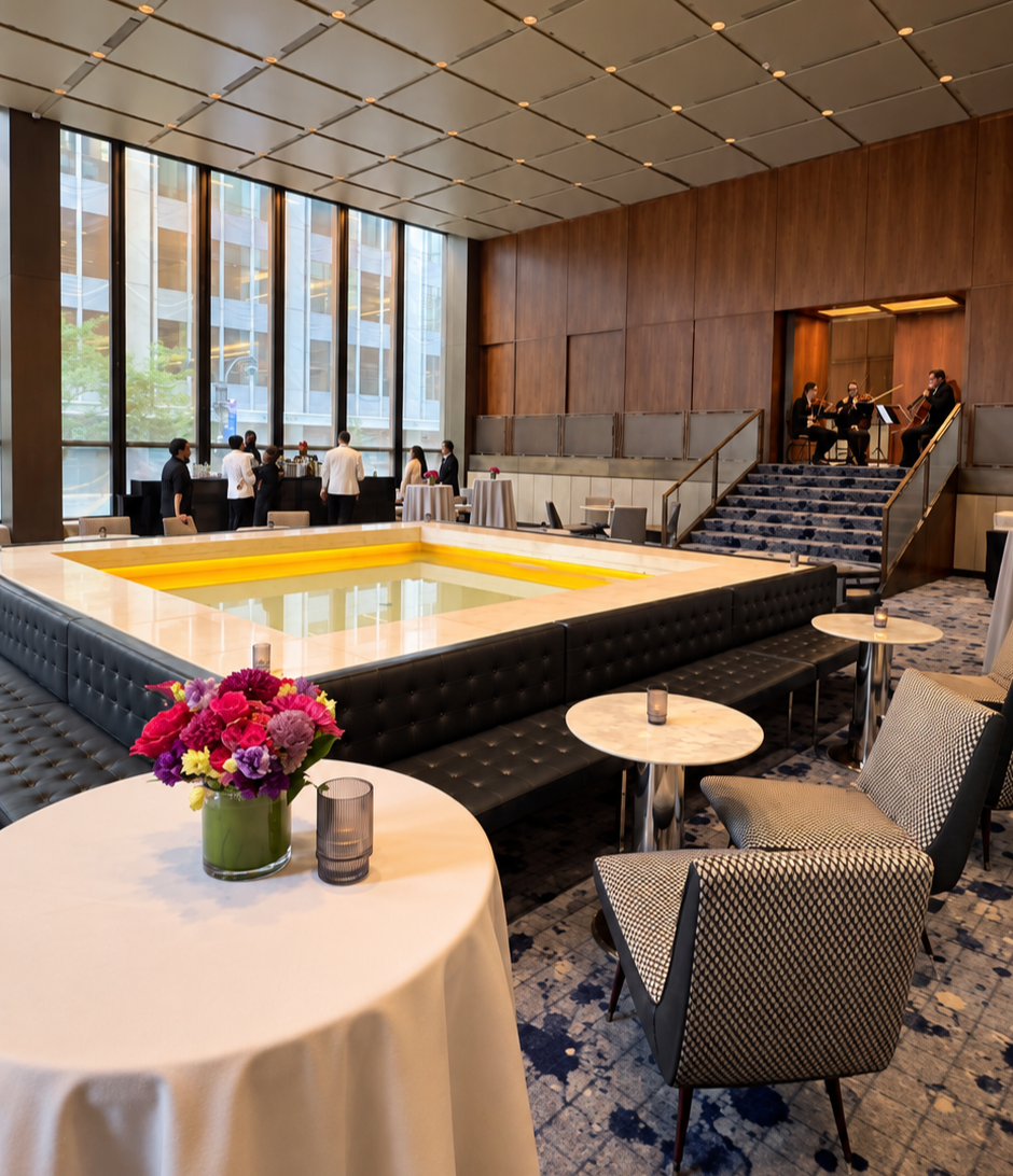 Corporate dinner setup at The Pool in Midtown Manhattan, with The J.M. Chamber Players performing on the staircase.