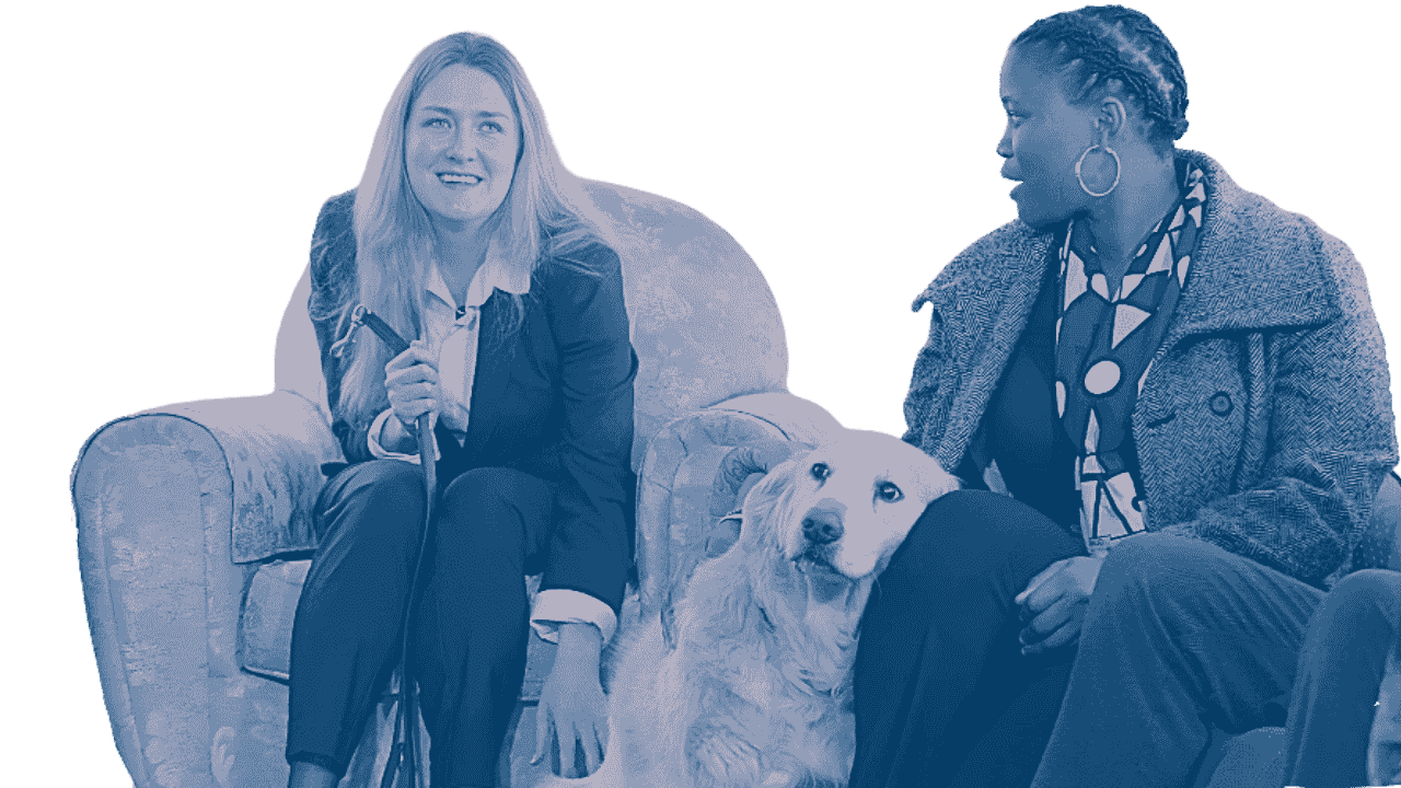 Two women and a dog sitting on a couch and having a conversation