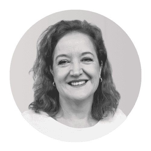 Black and white portrait of a woman with curly hair smiling at the camera