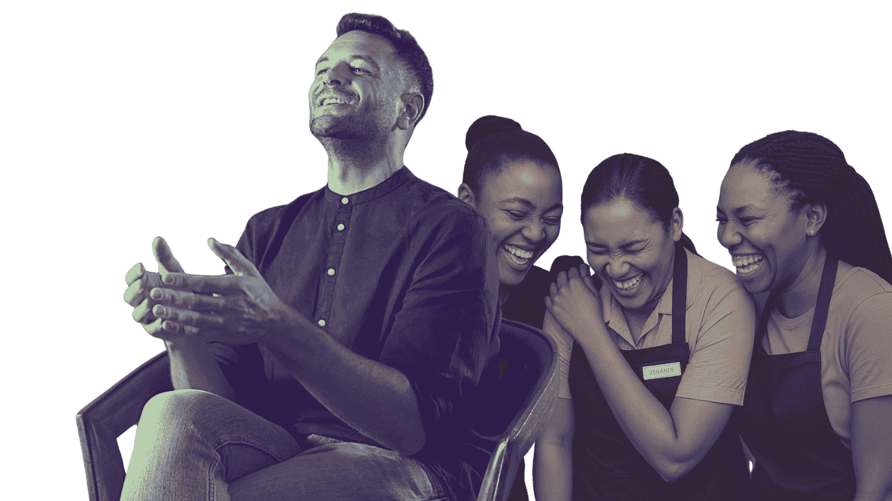 Four people laughing and smiling together, one man clapping, three women in aprons, black background