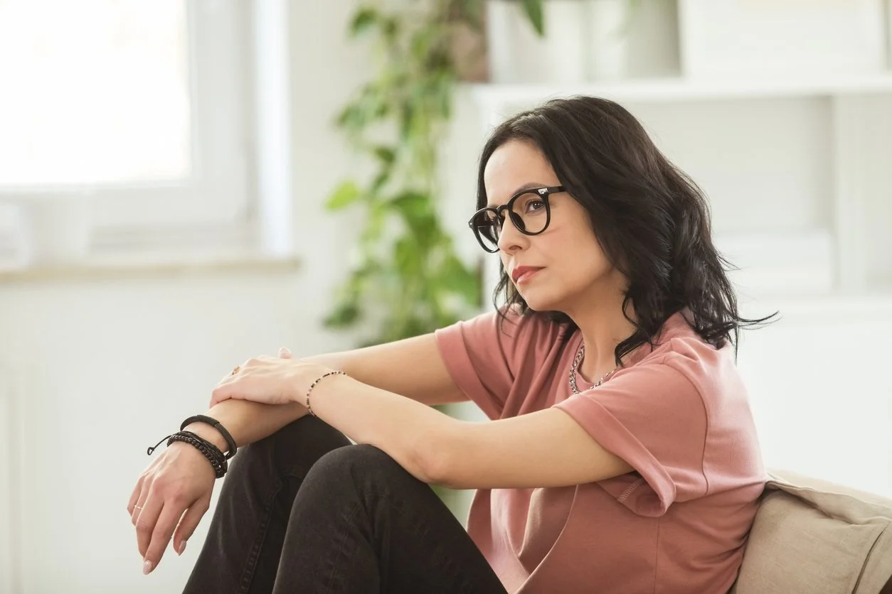 Thinking woman sitting on couch