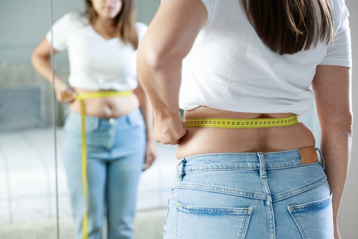 Woman measuring her waist
