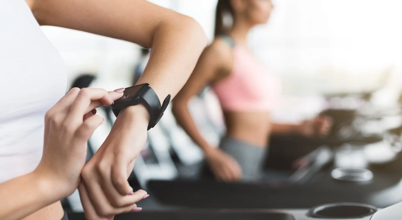 Women running on treadmills at a gym