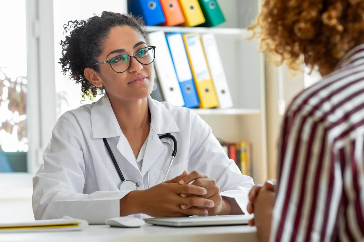 Female patient speaking with her physician in a doctor's office