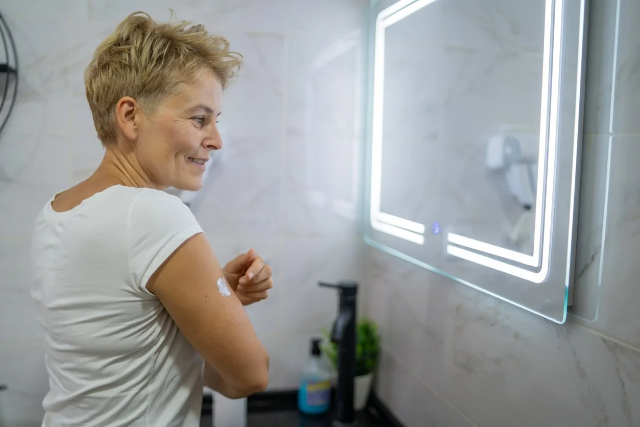 A woman applying her hormone replacement therapy
