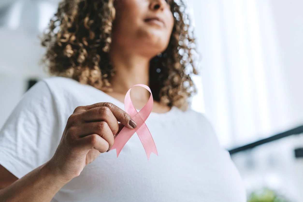 Woman holding a pink breast cancer awareness ribbon