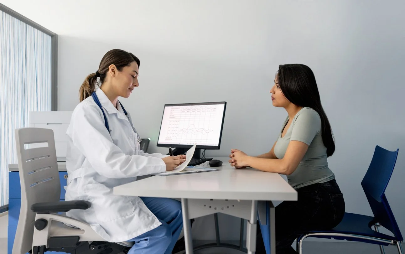 Doctor prescribing medicine to a young woman in a consultation