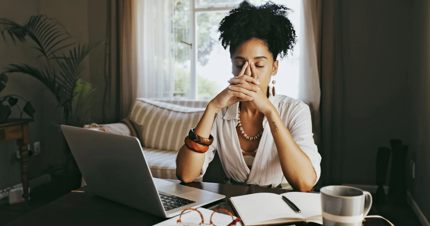 A woman experiencing stress and anxiety while working from home