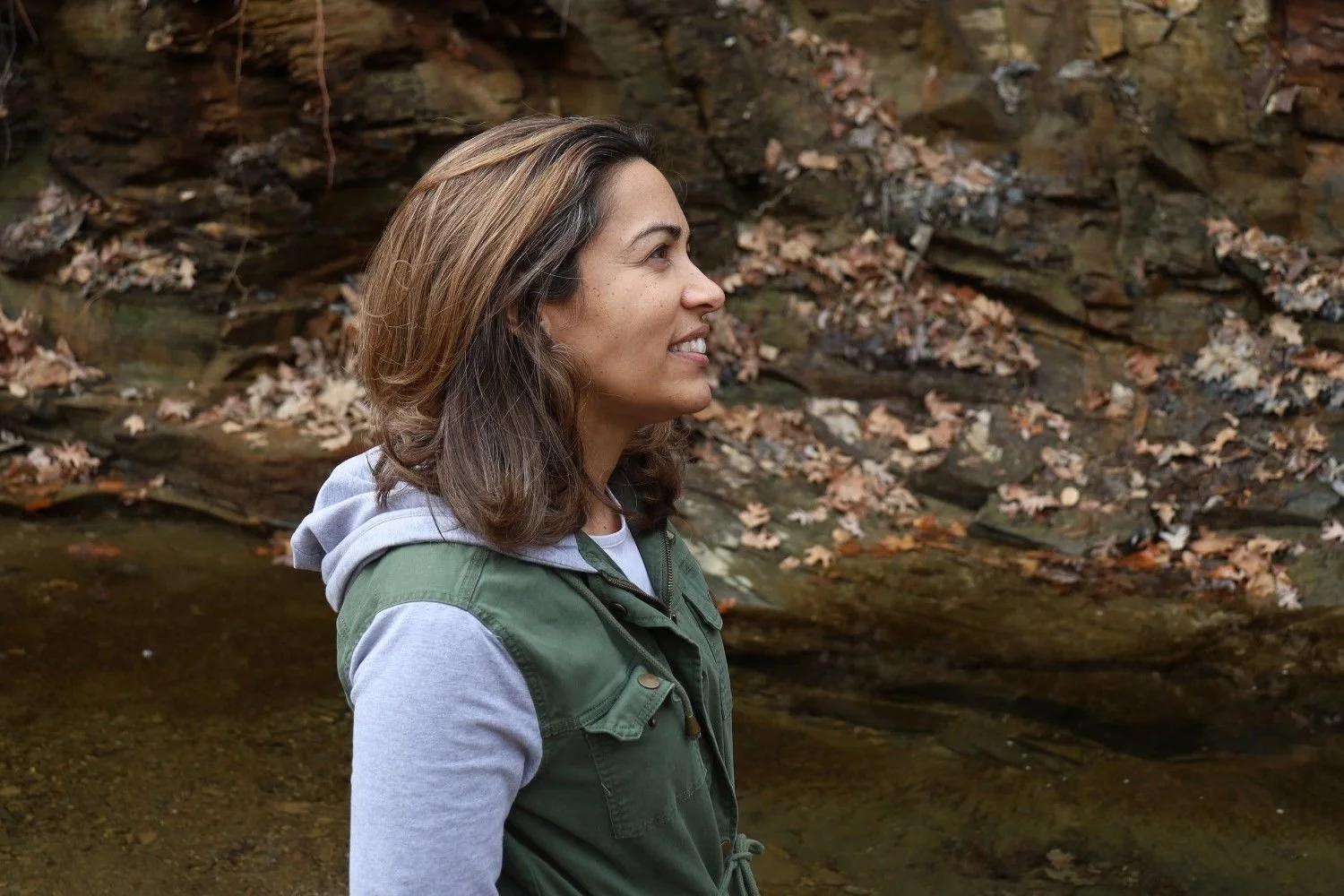 Dr. Sarah Bonza enjoying nature near a rocky stream