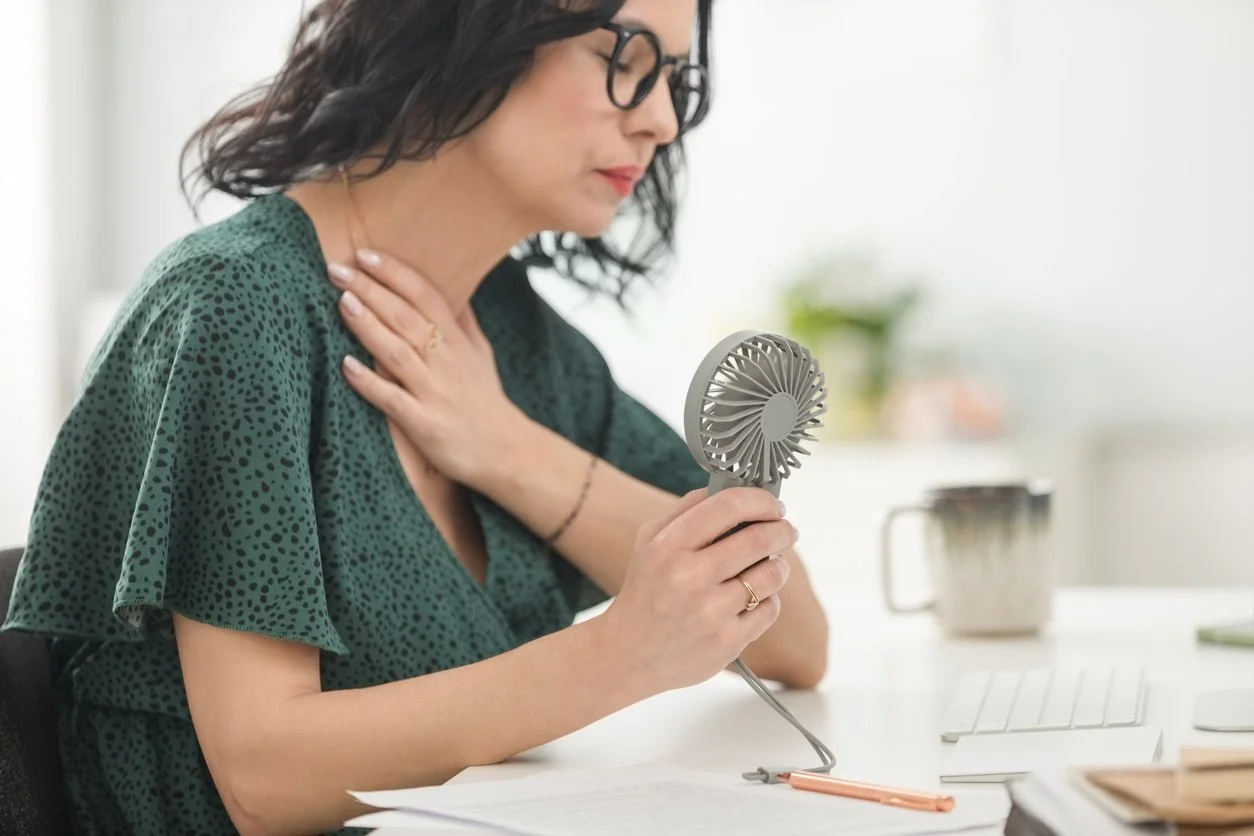 Midlife woman suffering hot flash in the office