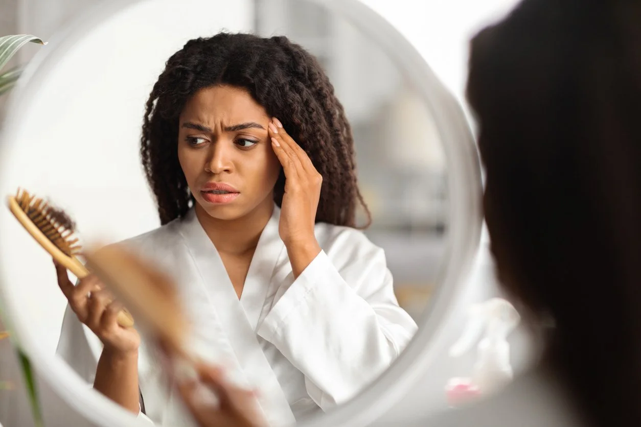 Black woman holding comb with fallen hair