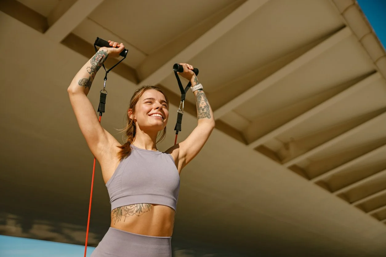 Smiling woman strength training with resistance bands