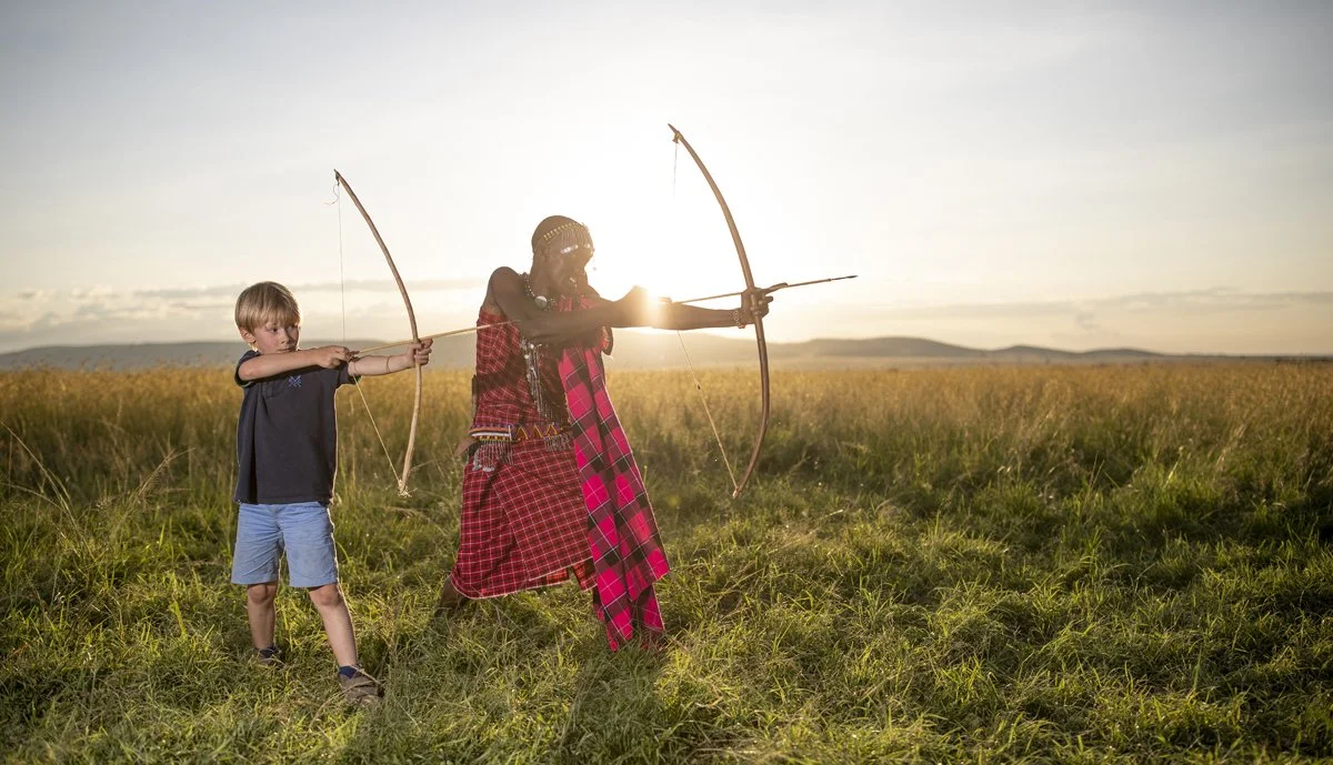 A child learns about Maasai Culture at Elewana Sand River Camp in the Masai Mara