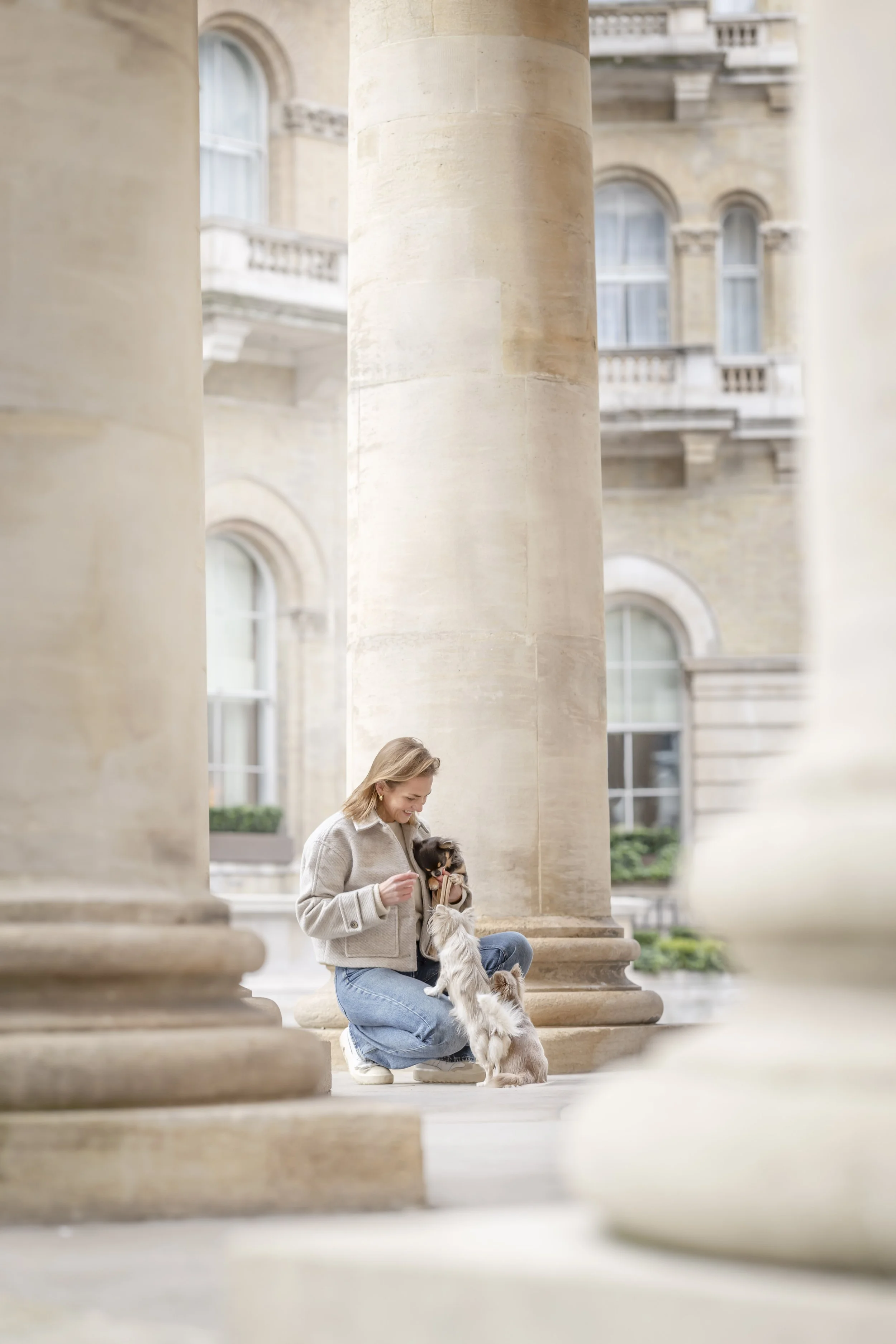 Fine art dog photograph by Andrew Raven of a woman kneeling with her three long-haired Chihuahuas in Mayfair, London