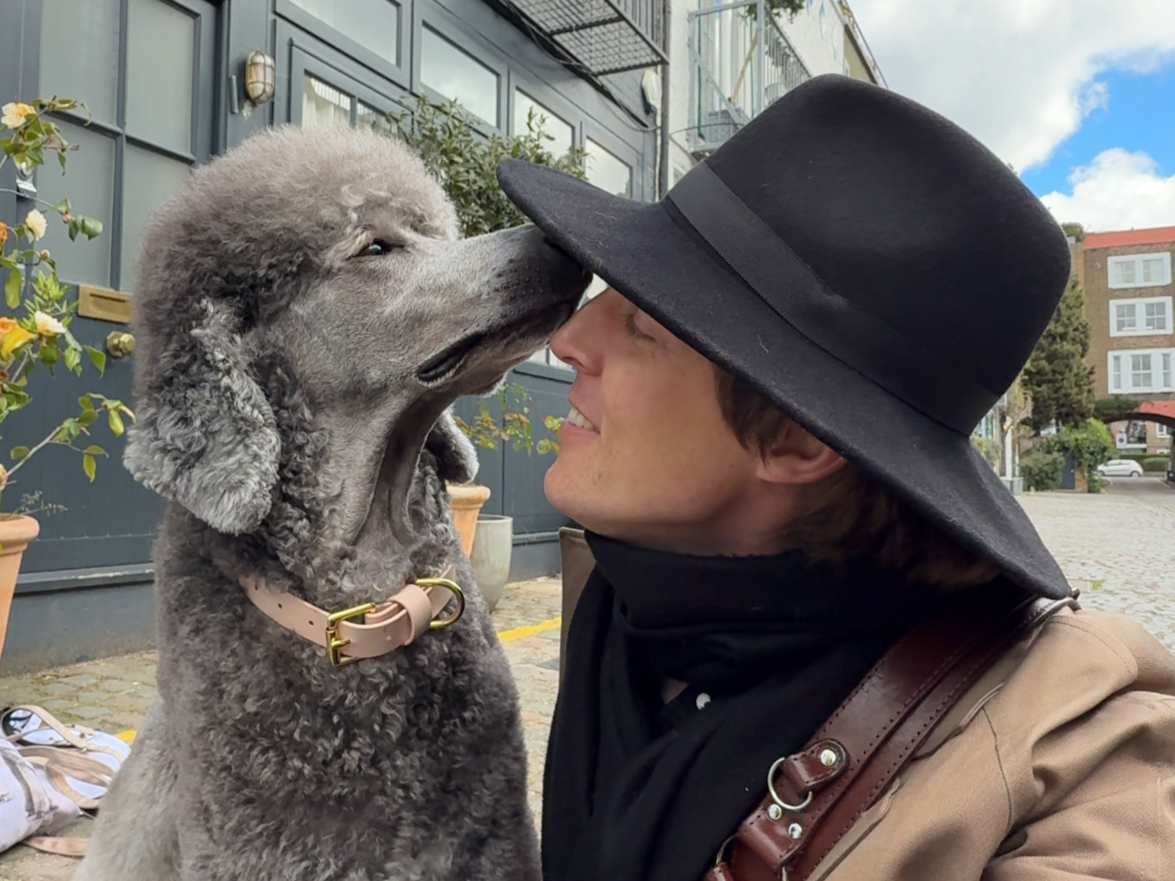 Andrew Raven sharing an affectionate moment with a grey Standard Poodle during a London portrait session.