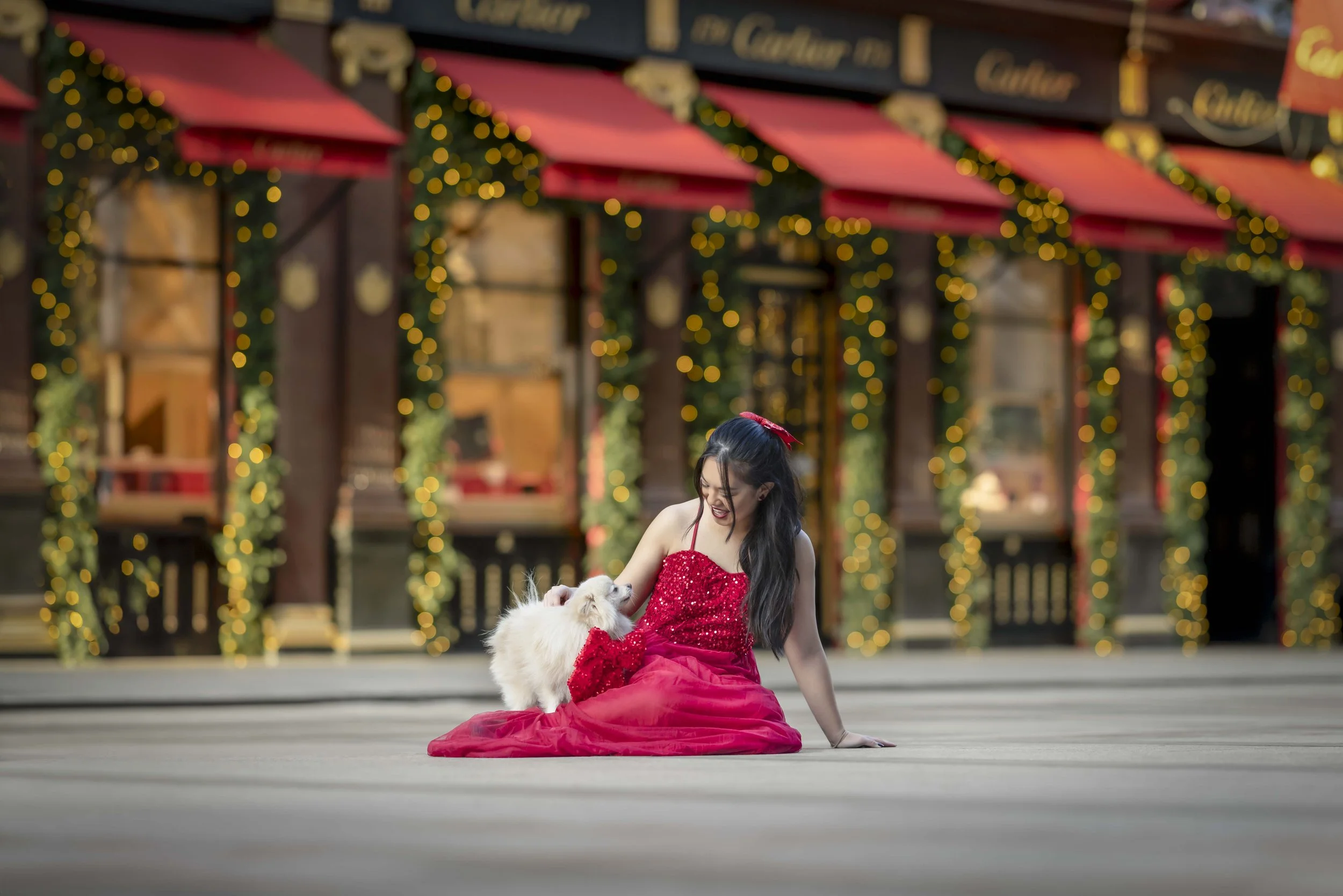 Marshier the Pomeranian with his mum during their Christmas dog photoshoot outside Cartier in Mayfair, London, surrounded by festive lights and decorations.
