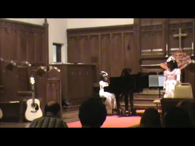 Two sisters perform a duet on piano and vocals/ percussion for a piano concert located in the Sanctuary of our Prestige Performers former teaching rooms