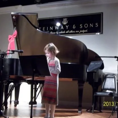 A young student performing the recorder for a concert at the Steinway Gallery