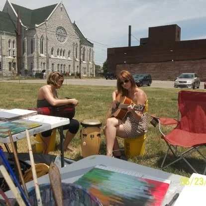 Two former teachers relaxing outside at the Fringe Festival drum circle improvisational sidewalk day
