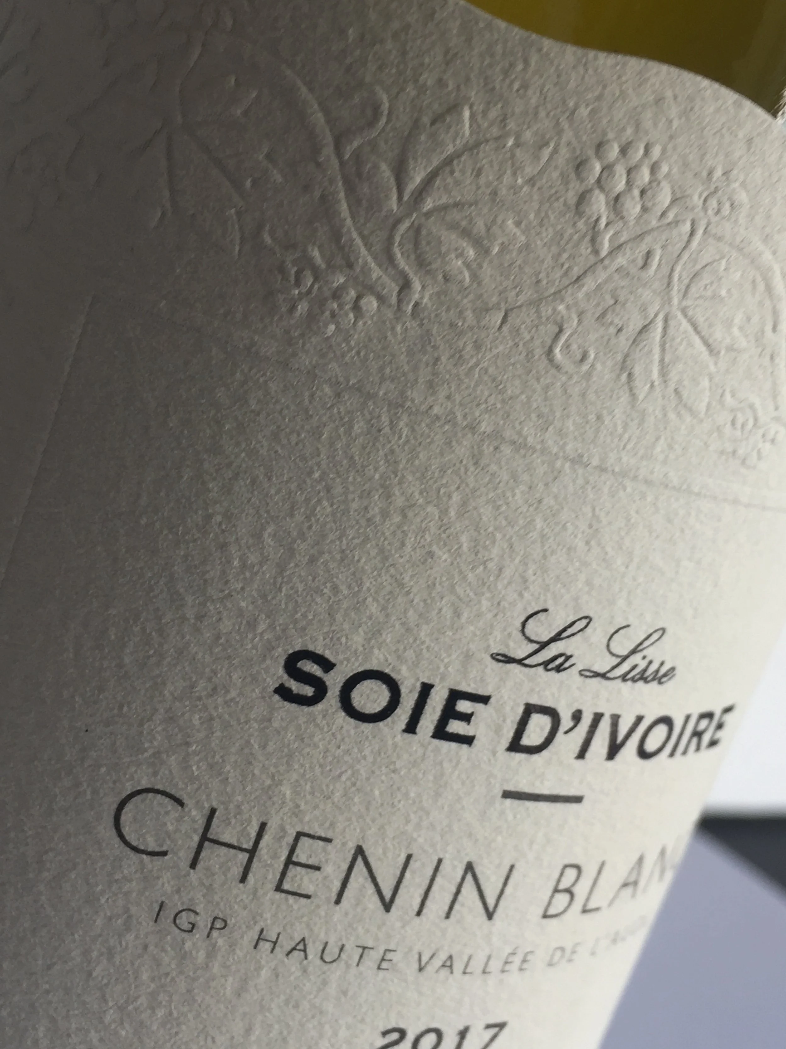 Close-up of a wine bottle label featuring embossed grapevine motif, with text in French including 'La Lise,' 'Soi D'Ivoire,' 'Chenin Blanc,' and vintage year 2017.