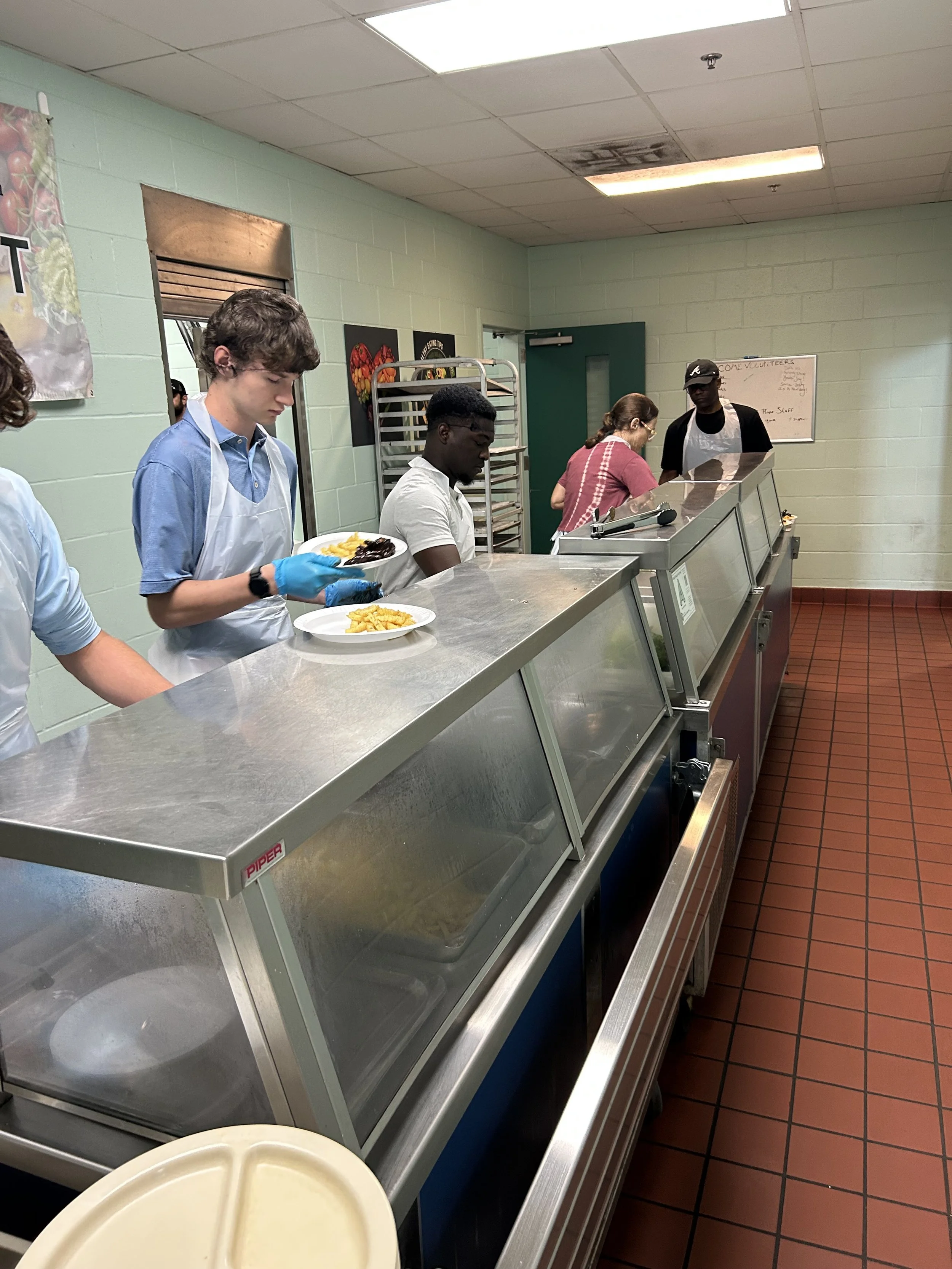 Gavin and Saterrence volunteered by serving lunch at Transitions in downtown Columbia