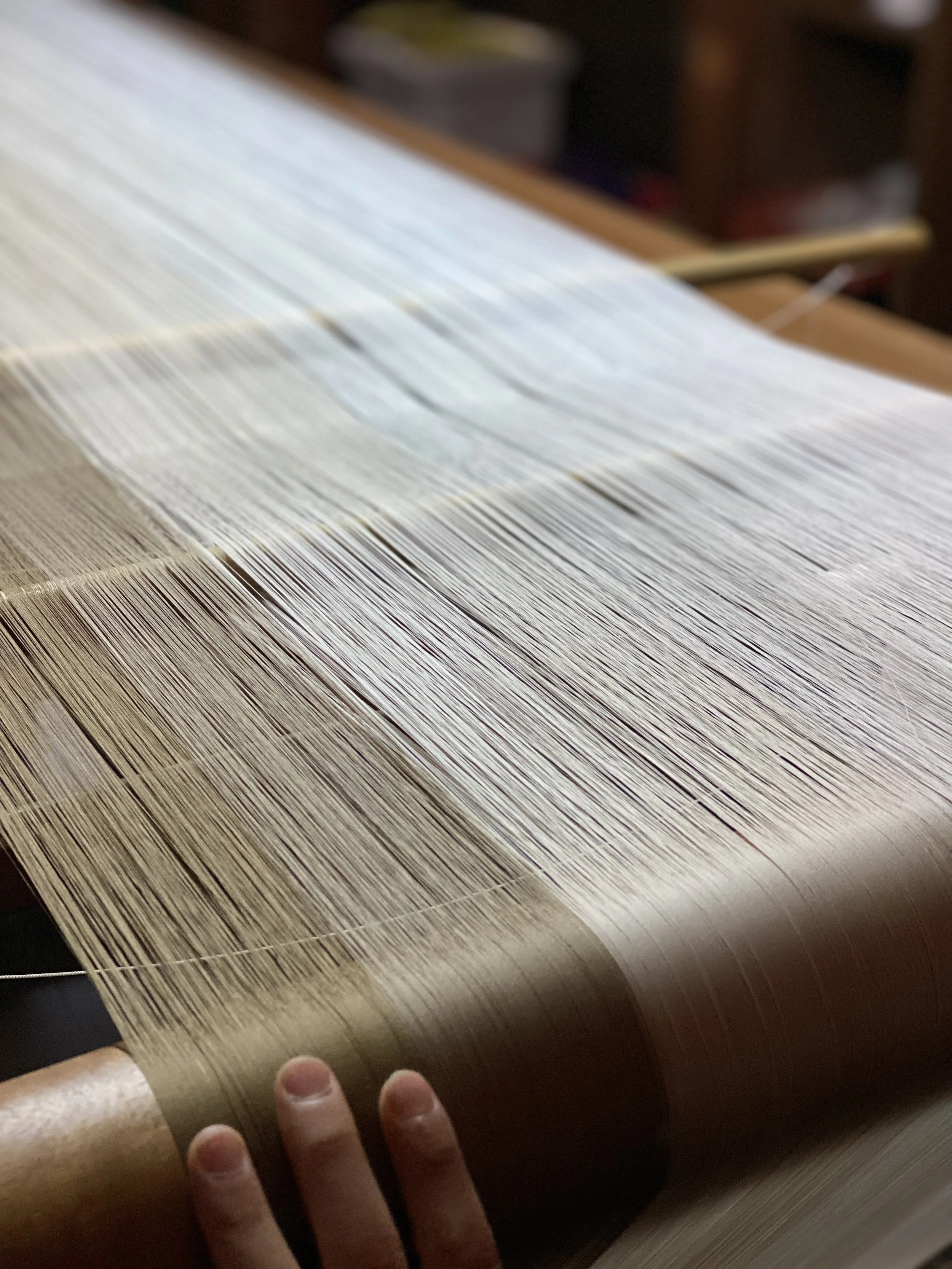 Natural silk — the warp, ready for weaving.

The fiber carries its own character — color, texture, and weight vary depending on origin, season, and the silkworm's diet. This is where every piece begins.