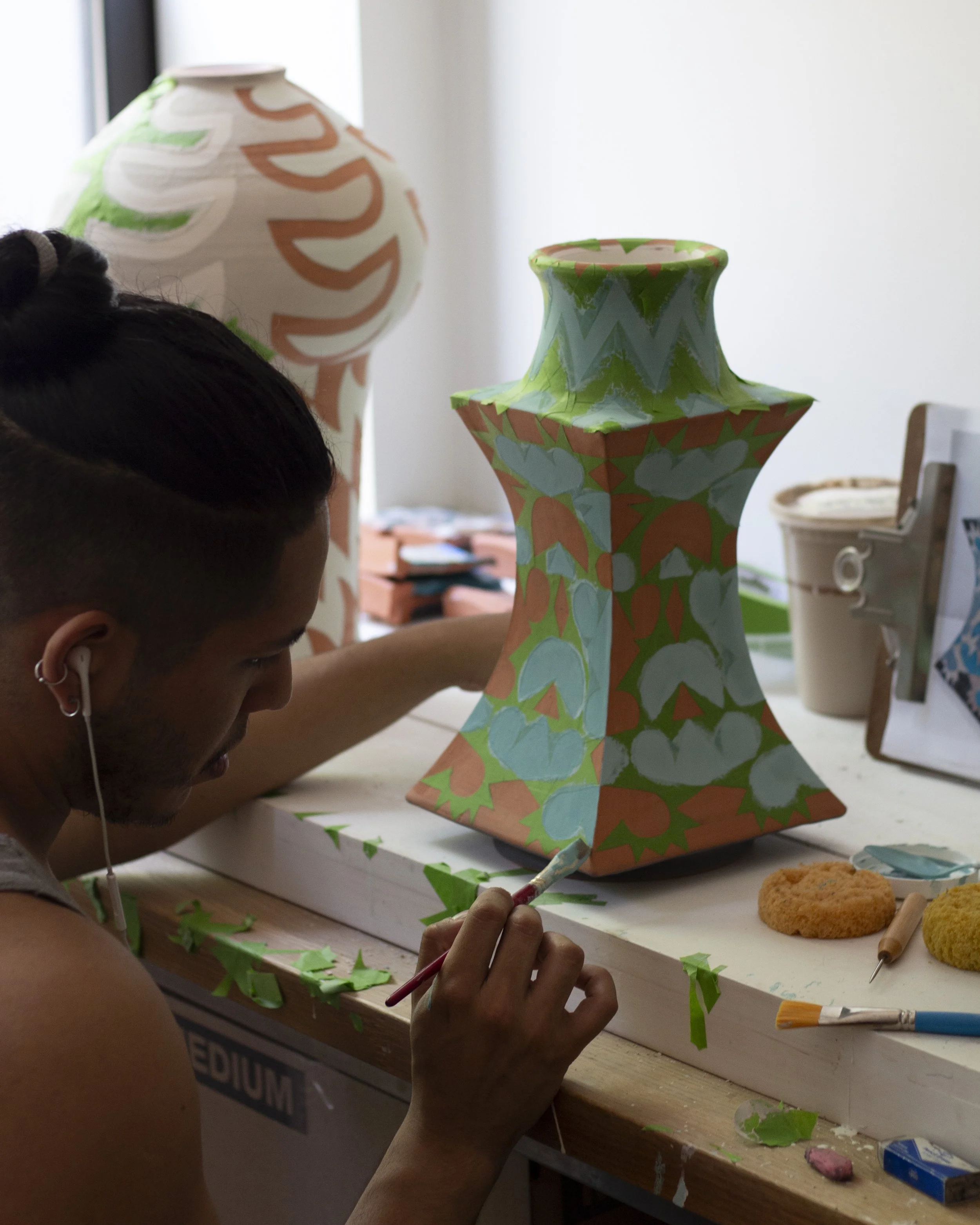 Francisco paints glaze on a terracotta albarello. 
