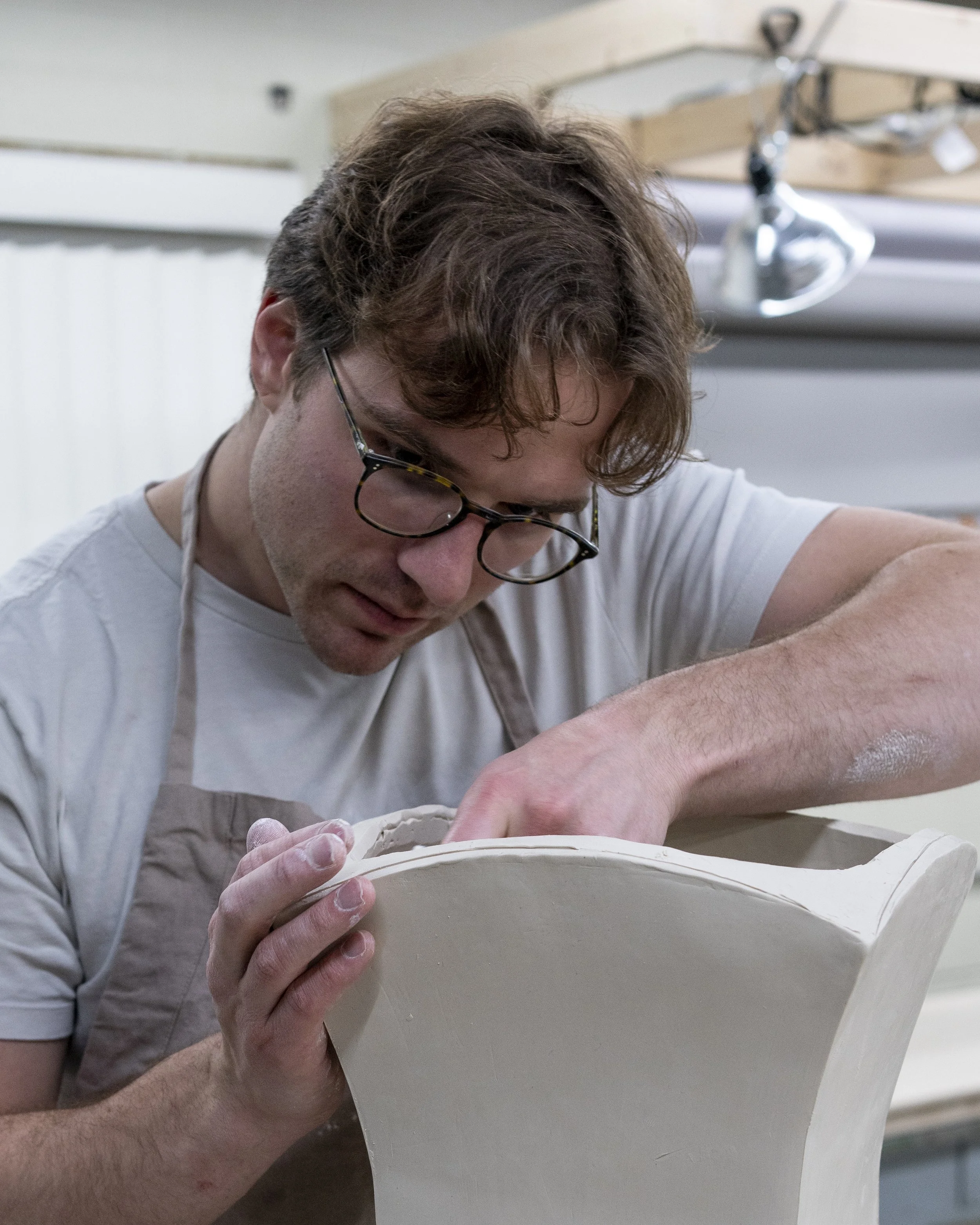 Jasper sculpts the form in clay assembling wheelthrown and handbuilt parts into graceful vessels.