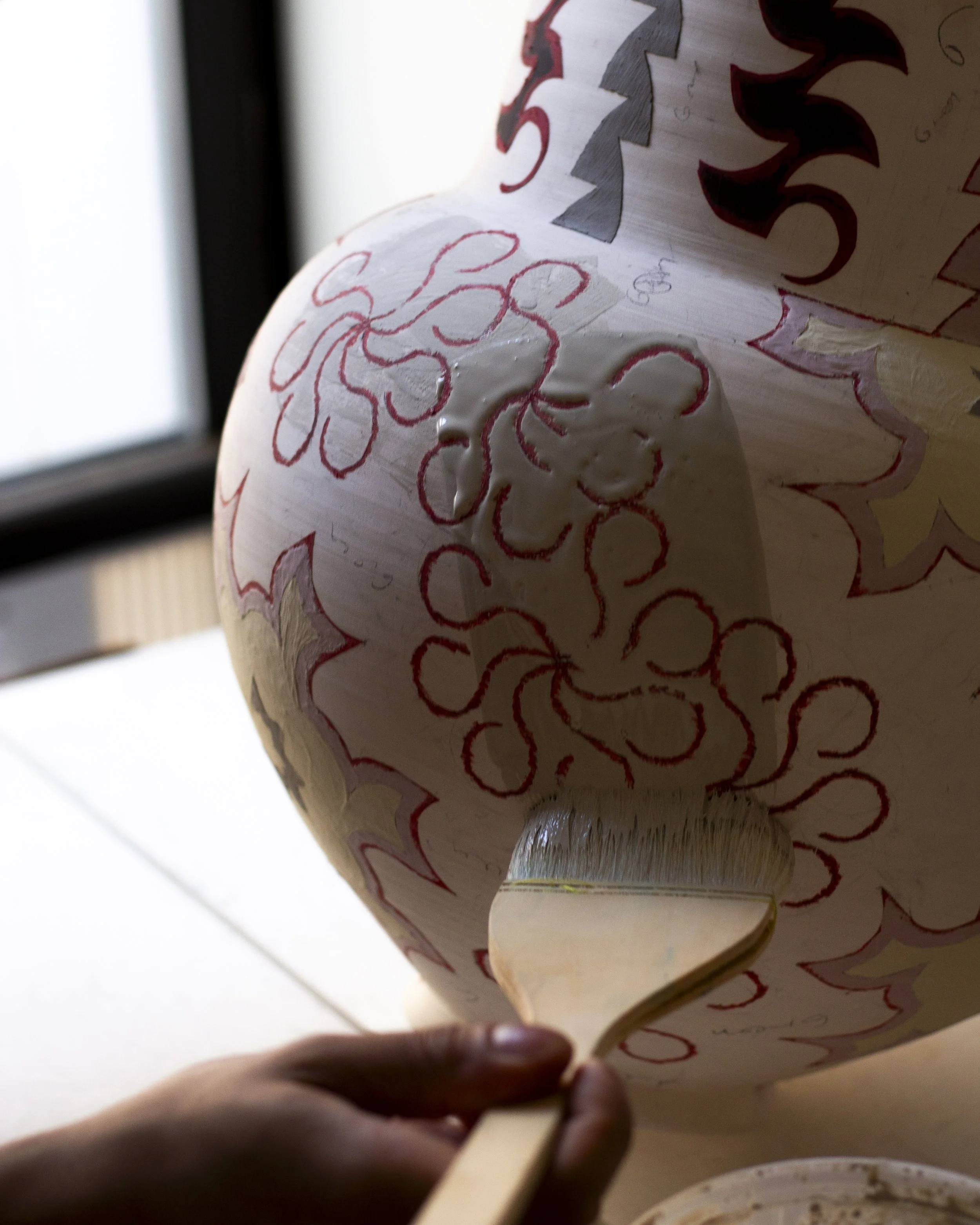 Francisco paints the final layer on  a porcelain baluster.