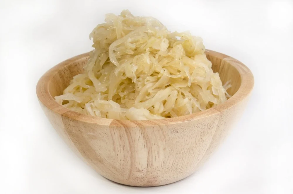 a wooden bowl filled with sauerkraut