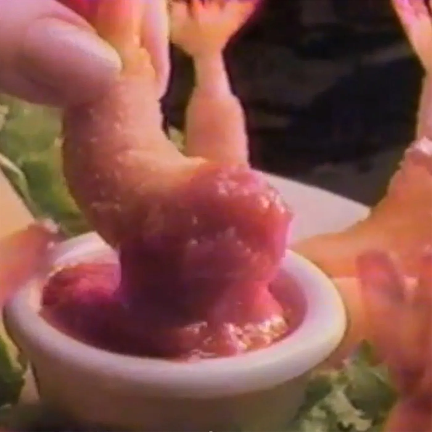 Close up of a hand dipping breaded shrimp into cocktail sauce. It's from a vintage red lobster commercial