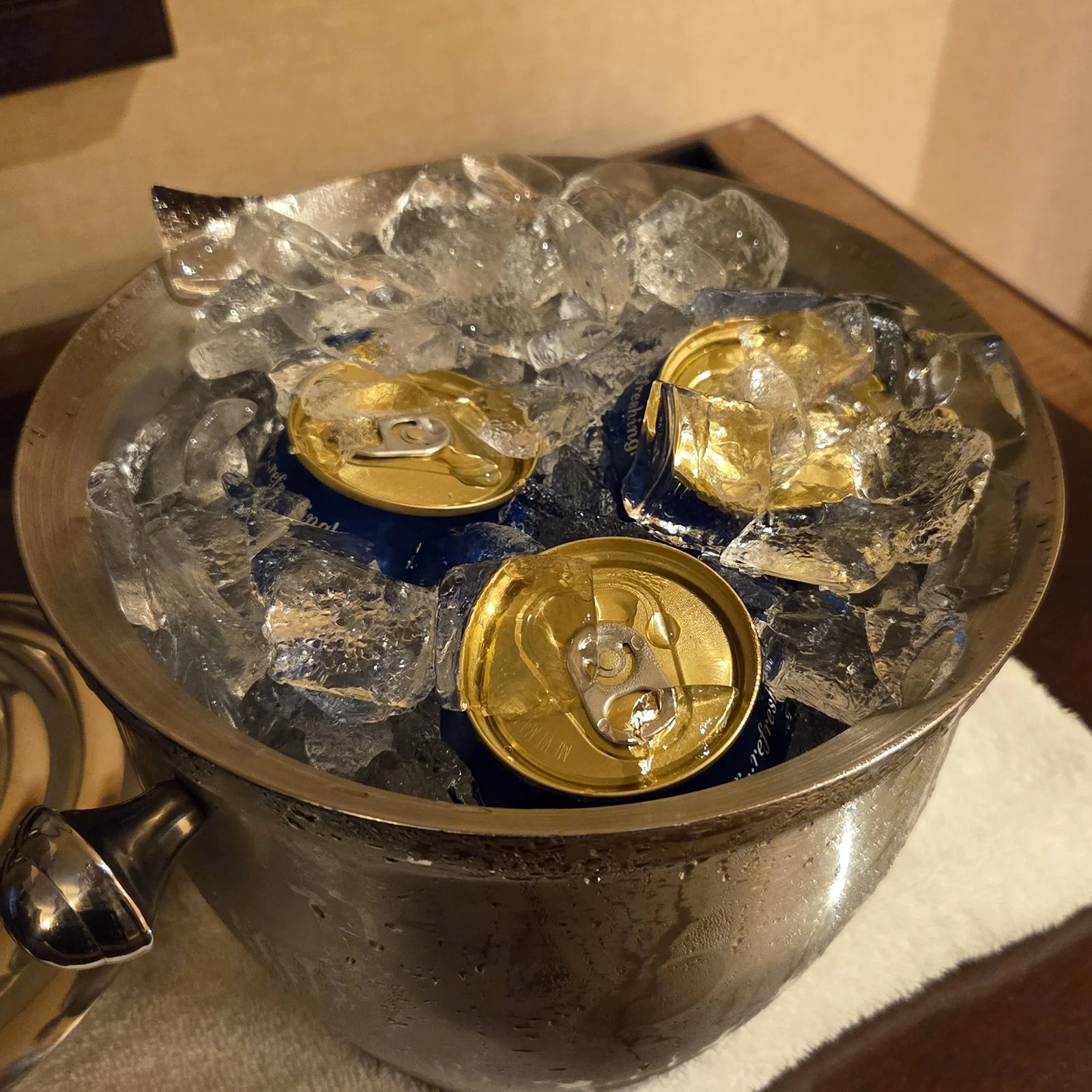 Photo of a hotel ice bucket filled with 3 cans of beer and lots of ice