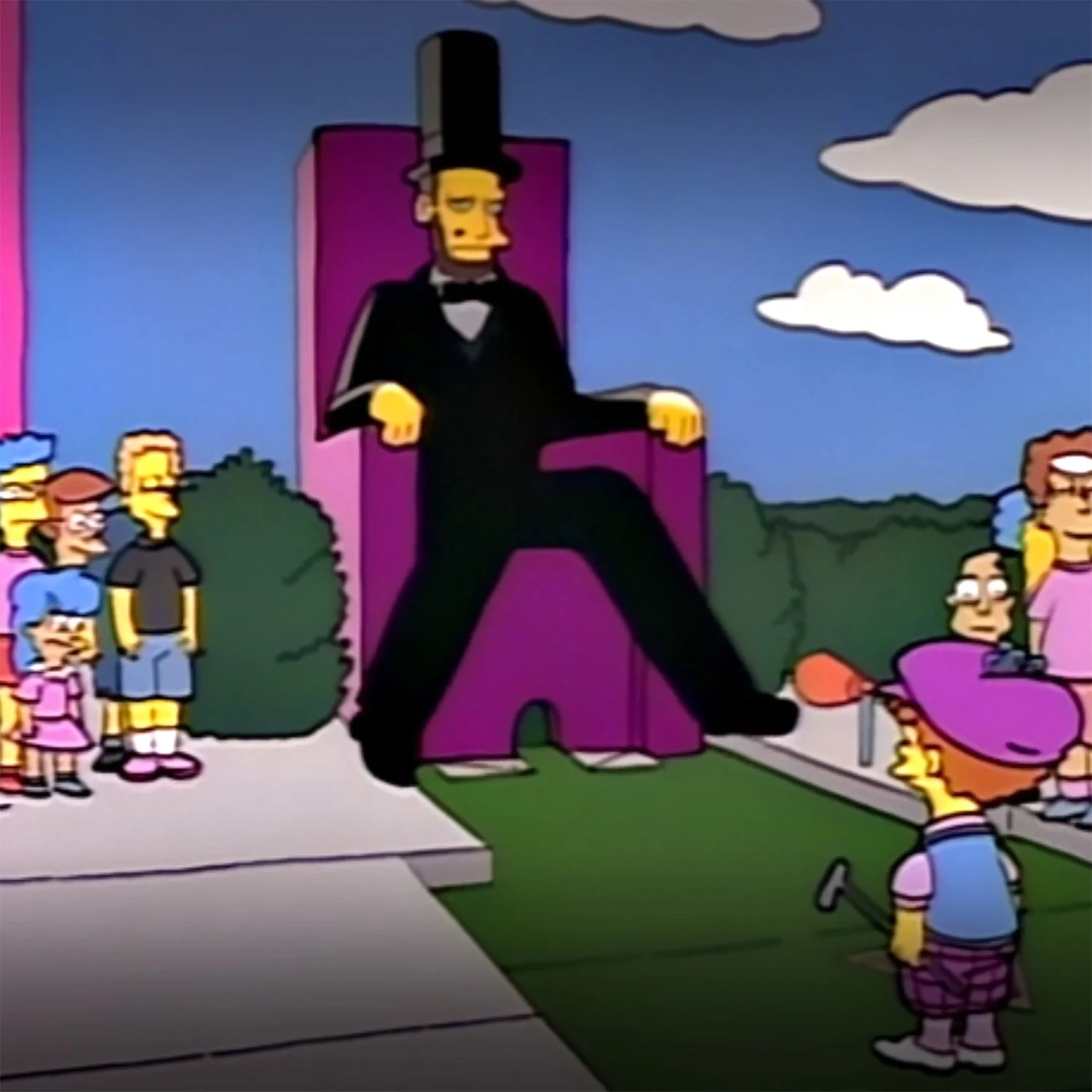 Image from the Simpsons showing families on a mini-golf course with a big recreation of Abraham Lincoln sitting over the final hole, his legs swinging in and out. You have to get the ball through his legs.