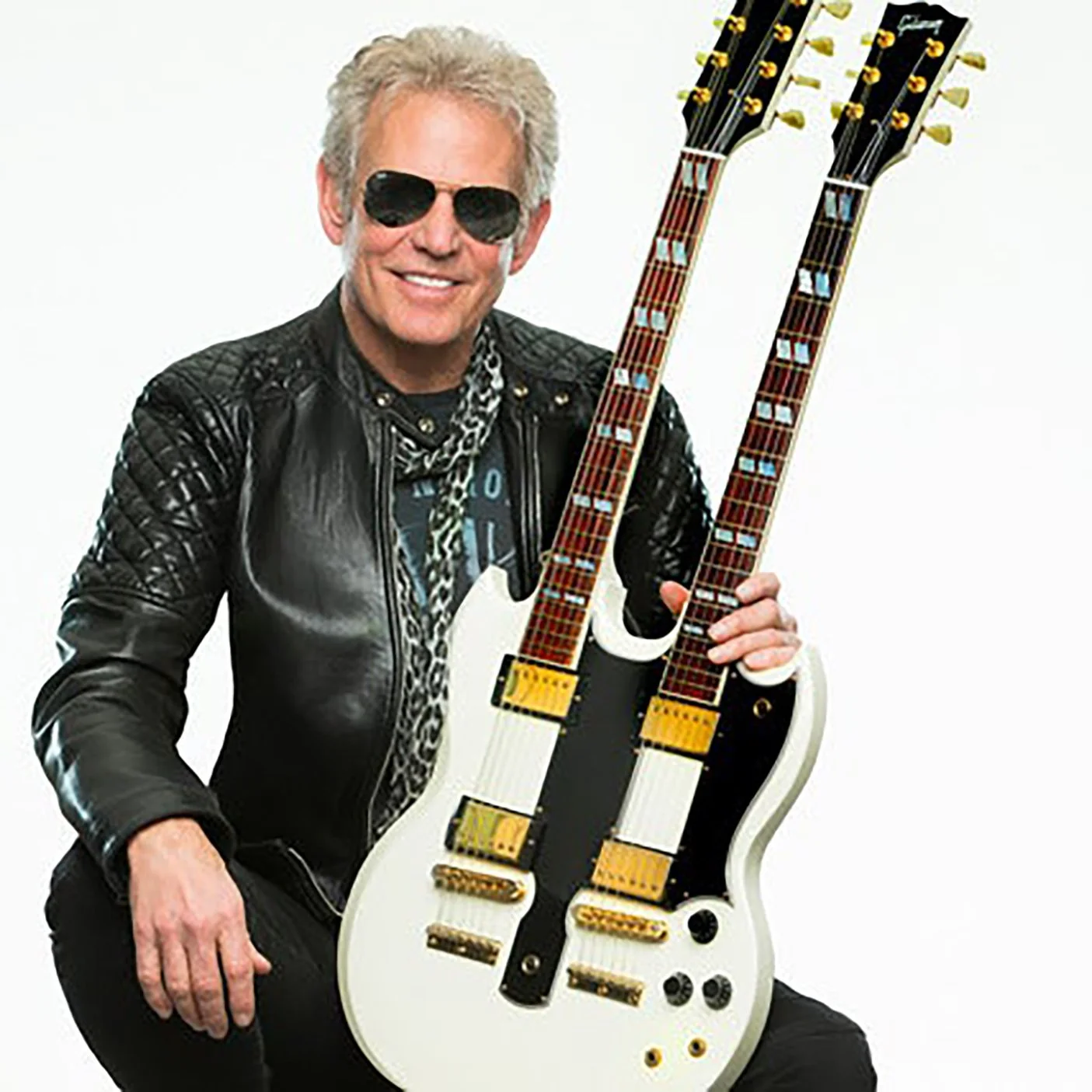 Promotional photo of guitarist Don Felder holding a double-necked guitar