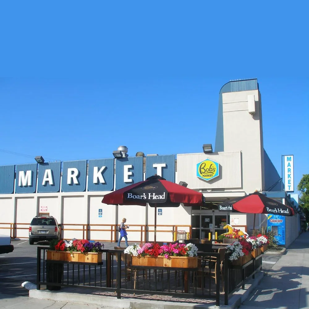 Photo of a cute store called Bob's Market -- classic Southern California signs and font that say MARKET. Outdoor patio on parking lot